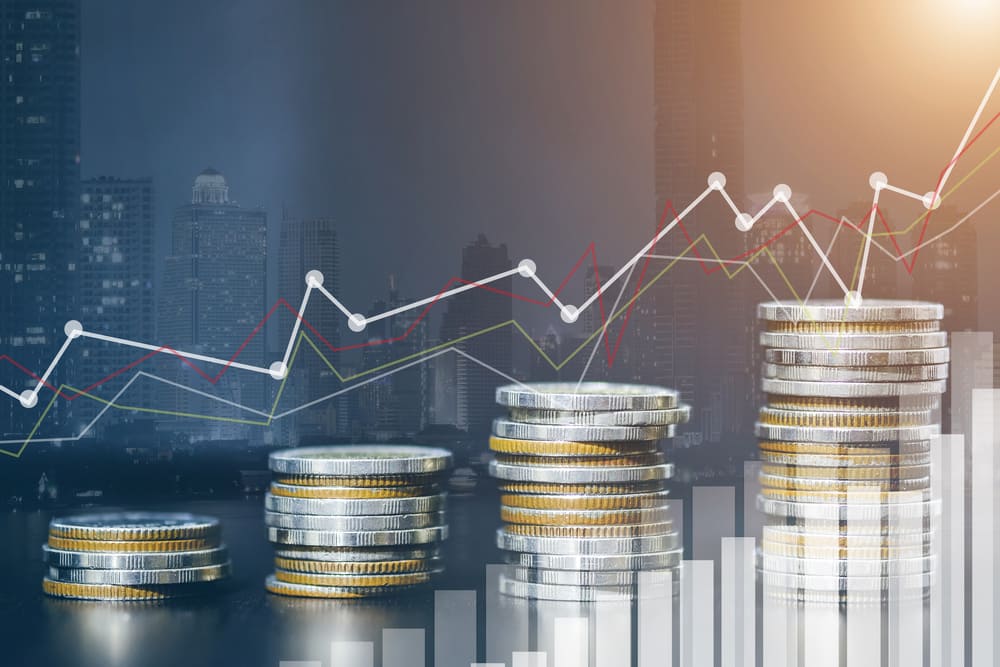 Gráfico financeiro sobre pilhas de moedas com cenário urbano ao fundo, simbolizando o crescimento de investimentos com liquidez diária no mercado.