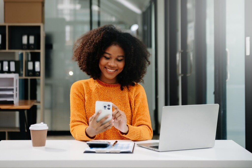 Investidora buscando investimento melhor que poupança pelo celular.
