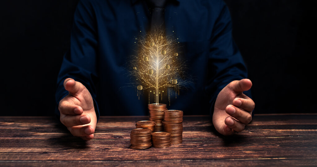 mãos em volta de moedas representando qual a melhor aplicação bancária