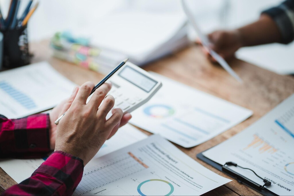 Pessoa analisando relatórios financeiros e gráficos para entender o LPA (Lucro por Ação) de uma empresa.