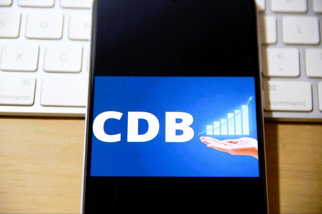 Tela de smartphone exibe a palavra CDB e um gráfico de crescimento, simbolizando o aumento de rendimentos em investimentos CDI ou CDB.