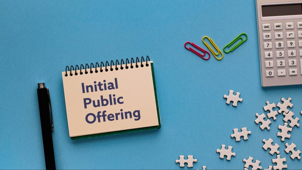 fundo azul com bloco de notas escrito "Initial Public Offering", da sigla IPO. Ao lado, uma caneta preta, clipes de papel, uma calculadora e peças de quebra-cabeça.