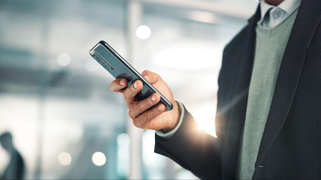 pessoa pesquisando no celular como investir na Bolsa de Valores