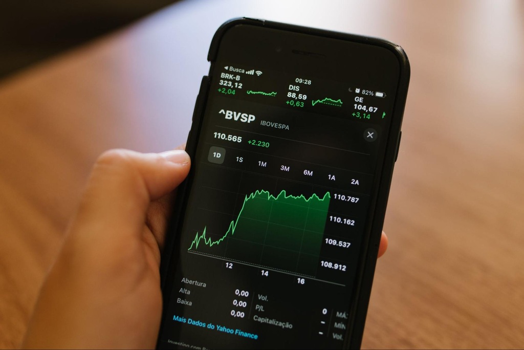Investidor acompanhando o Ibovespa pelo celular, com gráfico atualizado do índice Bovespa.
