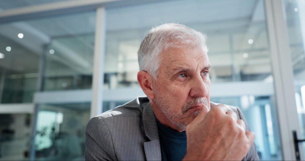 Homem pensando sobre o que considerar na hora de escolher o melhor banco para investir em renda fixa.