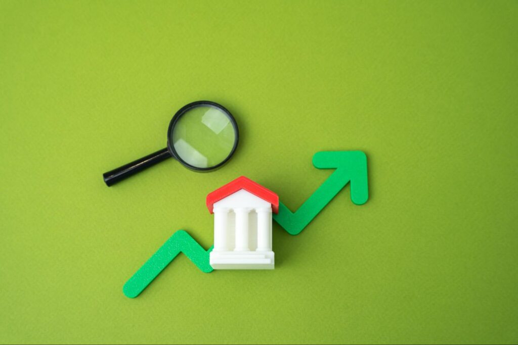 Ícones digitais de um banco, uma lupa e uma seta indicando cap rate.