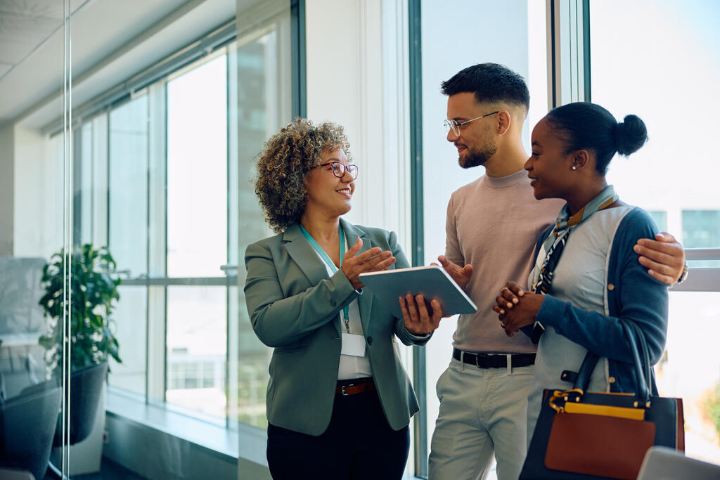 Três pessoas conversando sobre qual melhor para investir: banco físico ou digital.