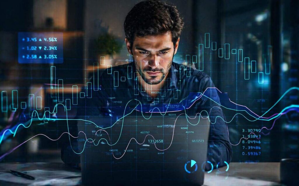 Homem analisando gráficos financeiros no computador em cenário de volatilidade do mercado e tomada de decisão.